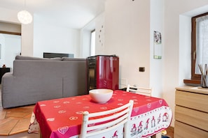 A dining area with a table set for two, a red tablecloth, and a white chair with a heart pattern. - Quiet apartment 'Nel Cuore di Tenno' with Mountain View (Tenno)