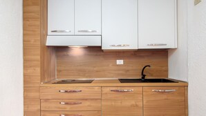 Une cuisine dotée de meubles en bois, d’un évier en acier inoxydable et d’un four encastré.