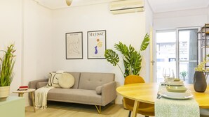 A modern living room with a sofa, a dining table, and two framed artworks on the wall. - Nice Apartment with Pool (Torrevieja)