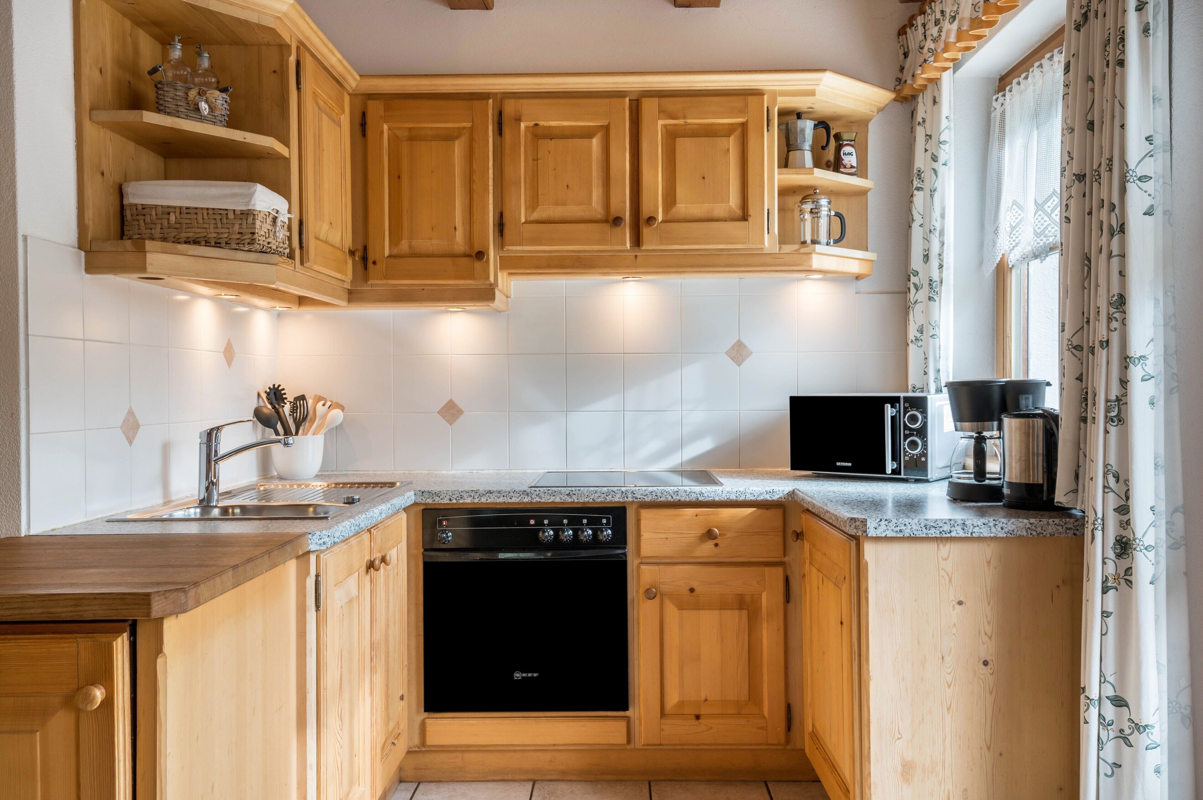 A kitchen with wooden cabinets, a dishwasher, a coffee maker, and a microwave.