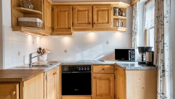 A kitchen with wooden cabinets, a dishwasher, a coffee maker, and a microwave.