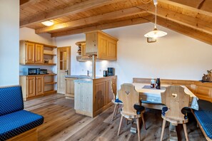 Un intérieur en bois comprenant un coin repas, une cuisine et un espace détente.