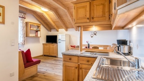 A kitchen with wooden cabinets, a granite countertop, a stainless steel sink, and a built-in oven. - Apartment 'Kranebitterhof Alpenrose' with Mountain View, Shared Garden and Wi-Fi (Valdaora)
