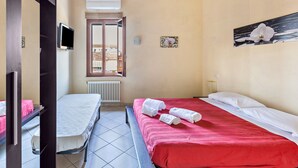 A bedroom with a bed, a bench, a TV, and a window with a view. - Apartment 'Verona' with Shared Garden, Wi-Fi and Air Conditioning (VERONA)