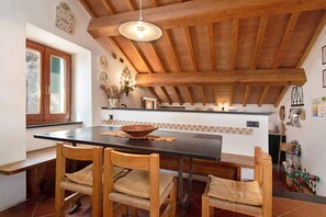 Una cocina con vigas de madera, una isla grande y una zona de comedor con sillas.