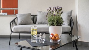 A glass table with a potted plant, a glass of water, and a bowl of fruit. - Apartment 'Suite Marianne' with Mountain View, Private Terrace and Wi-Fi (Valdaora)
