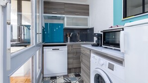 Eine kompakte Küche mit Geschirrspüler, Waschmaschine und Mikrowelle.