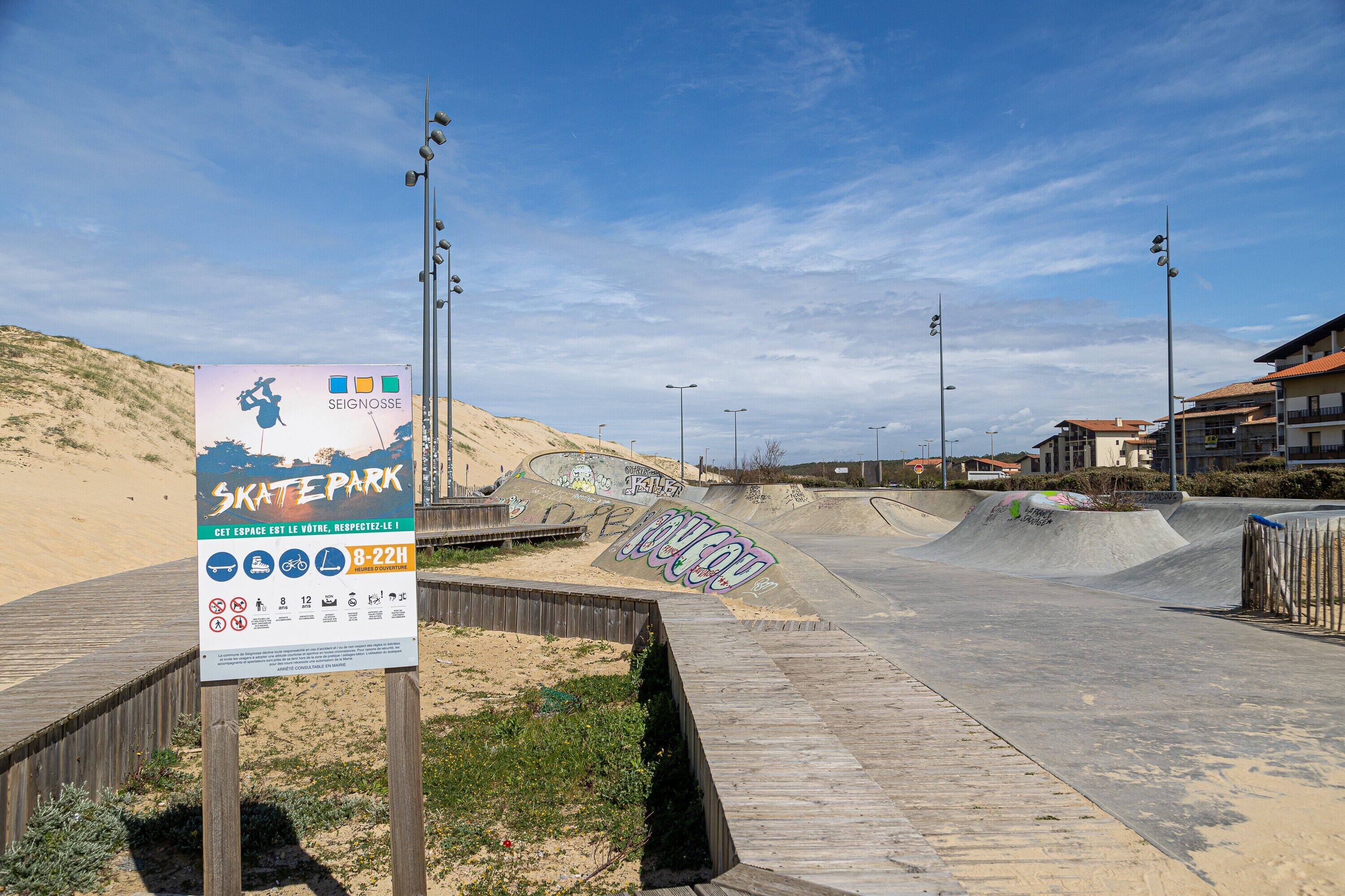 Un skatepark doté d’une promenade en bois, de rampes et de graffitis.