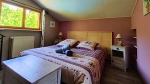 A bedroom with a bed, two bedside tables, a window, and a radiator. - Le Chalet Cosy - Label Valeurs Parc Naturel Régional (Weiterswiller)