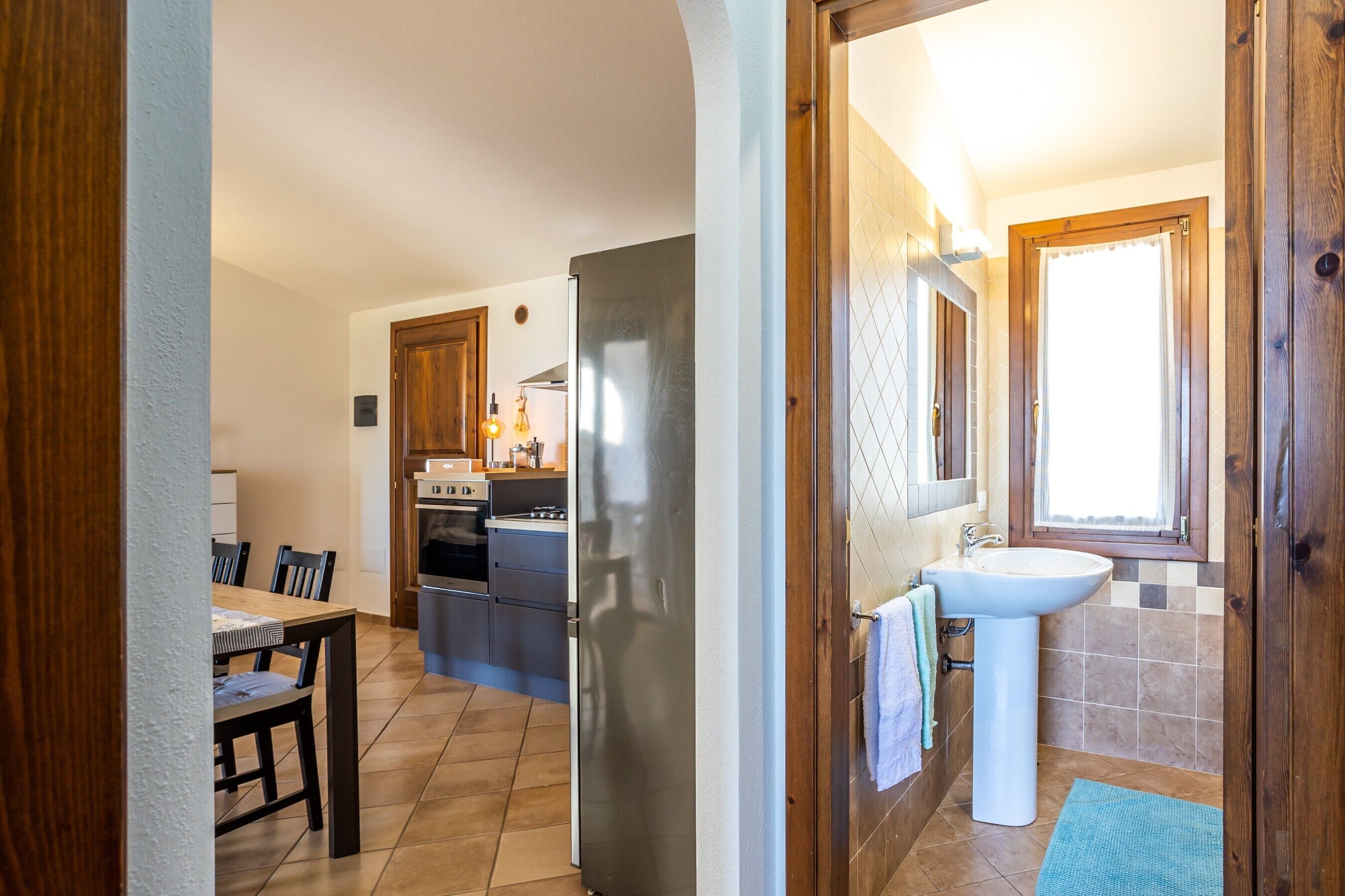 Una cocina equipada con refrigerador, horno y mesa de comedor.