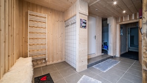 Et træinteriør med sauna, flisegulv og en hvid bænk.