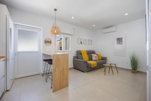 Un salon moderne avec un canapé, une petite table et une plante.