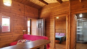 A wooden cabin interior with a bed, a bench, and a shower area. - Holiday Home "Casa Juana Madera" with Shared Pool and Air Conditioning (Zahora)