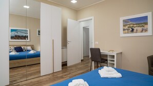 A room with a bed, a desk, a chair, a wardrobe, and a painting on the wall. - Holiday Apartment "Violet House" with Private Terrace, Air Conditioning and Wi-Fi (Catania)