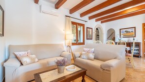 Ein Wohnzimmer mit zwei Sofas, einem Couchtisch und einem Essbereich mit Stühlen und einem Tisch.
