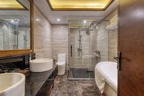 Une salle de bain moderne dotée d’une douche à parois de verre, d’une baignoire et de deux lavabos.
