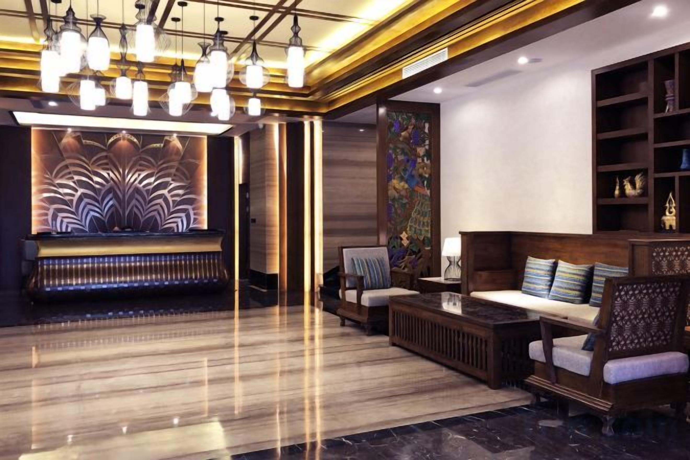 A modern lobby with a reception desk, seating area, and decorative wall art.