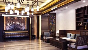 Een moderne lobby met een piano, zithoek en decoratieve verlichting.