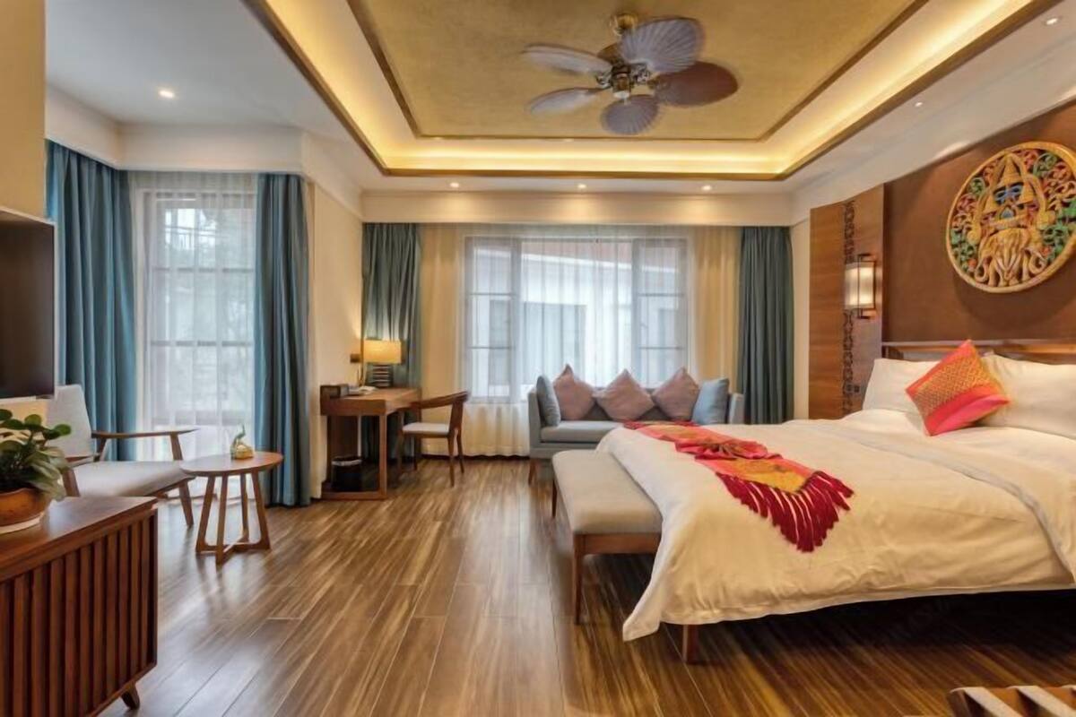 Een hotelkamer met een groot bed, een bureau en een zithoek.