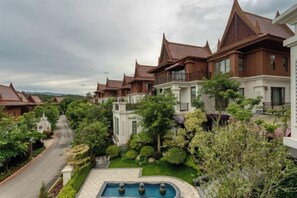 Un complexe hôtelier comprenant plusieurs villas, une piscine et une végétation luxuriante.