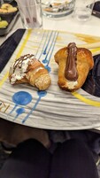 Un plato con dos pasteles, uno cubierto de chocolate y el otro de crema batida y chocolate.