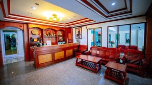A lobby with a reception desk, wooden furniture, and a chandelier. - Wanna Marine (Patong)