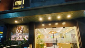 A hotel entrance with a reception desk, a staircase, and a sign indicating the hotel name and number. - Hotel Herencia 625 (Daraga)