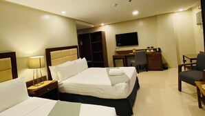 A hotel room with two beds, a desk, a chair, a TV, and a wardrobe. - Hotel Herencia 625 (Daraga)
