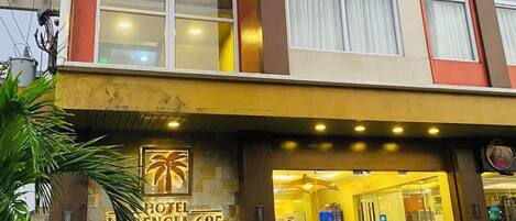 A hotel entrance with a sign reading 'HOTEL RENOVIA 625,' a glass facade, and a metal staircase leading up to the entrance.