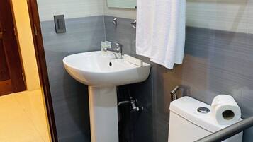 A bathroom with a sink, toilet, and a towel rack.