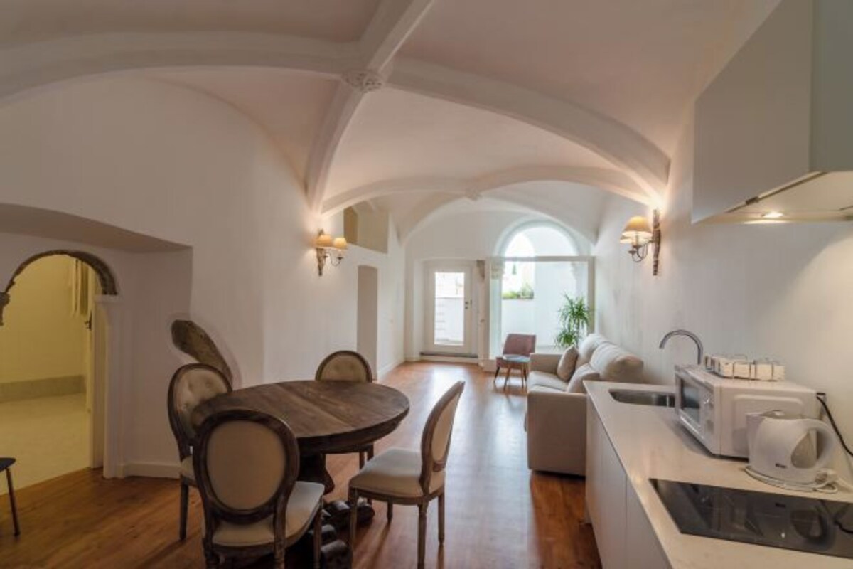 Una cocina amplia con comedor, que incluye una mesa y sillas de madera, un microondas empotrado y un lavamanos moderno.
