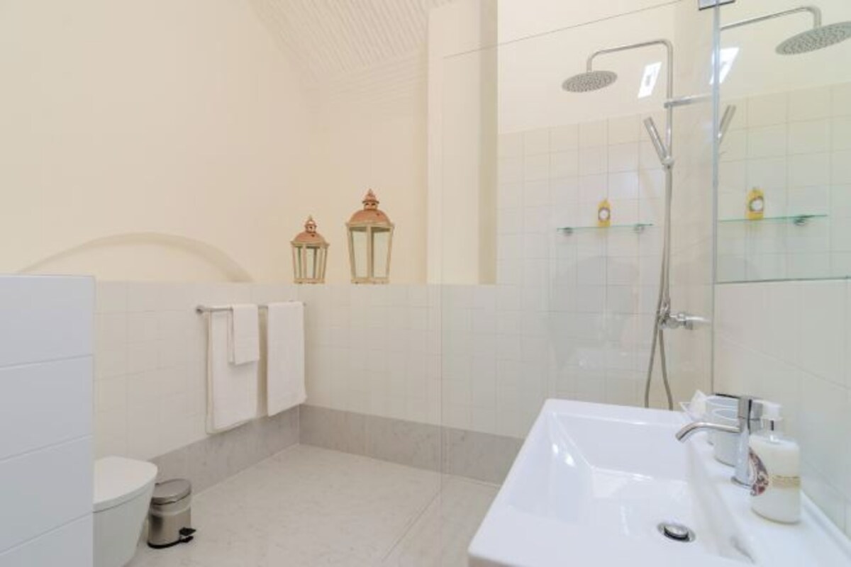 Un baño moderno con inodoro, lavamanos y ducha.