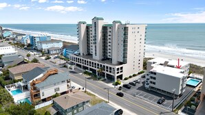 Un hôtel situé sur la côte, avec plusieurs étages, une piscine et une vue sur la plage.