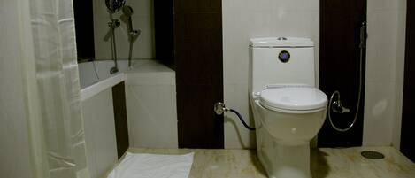 A bathroom with a toilet, a shower, and a bathtub.
