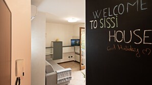 A modern interior with a blackboard displaying "WELCOME TO SISSI HOUSE" and "Good Holiday."