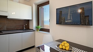 A modern kitchen with white cabinets, a stainless steel sink, and a window overlooking a scenic view.