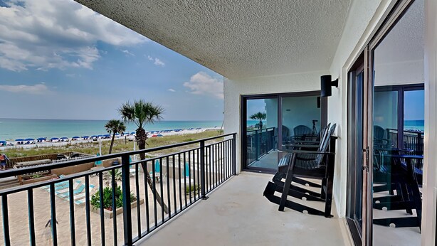 A balcony with a view of the beach, outdoor furniture, and a glass door leading to an interior space. - Emerald Isle #300 | Balcony Views, Pool Access, Near Area Dining & Fun! (Fort Walton Beach)