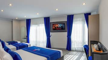 A hotel room with two beds, a desk, a chair, a TV, and a window with curtains.