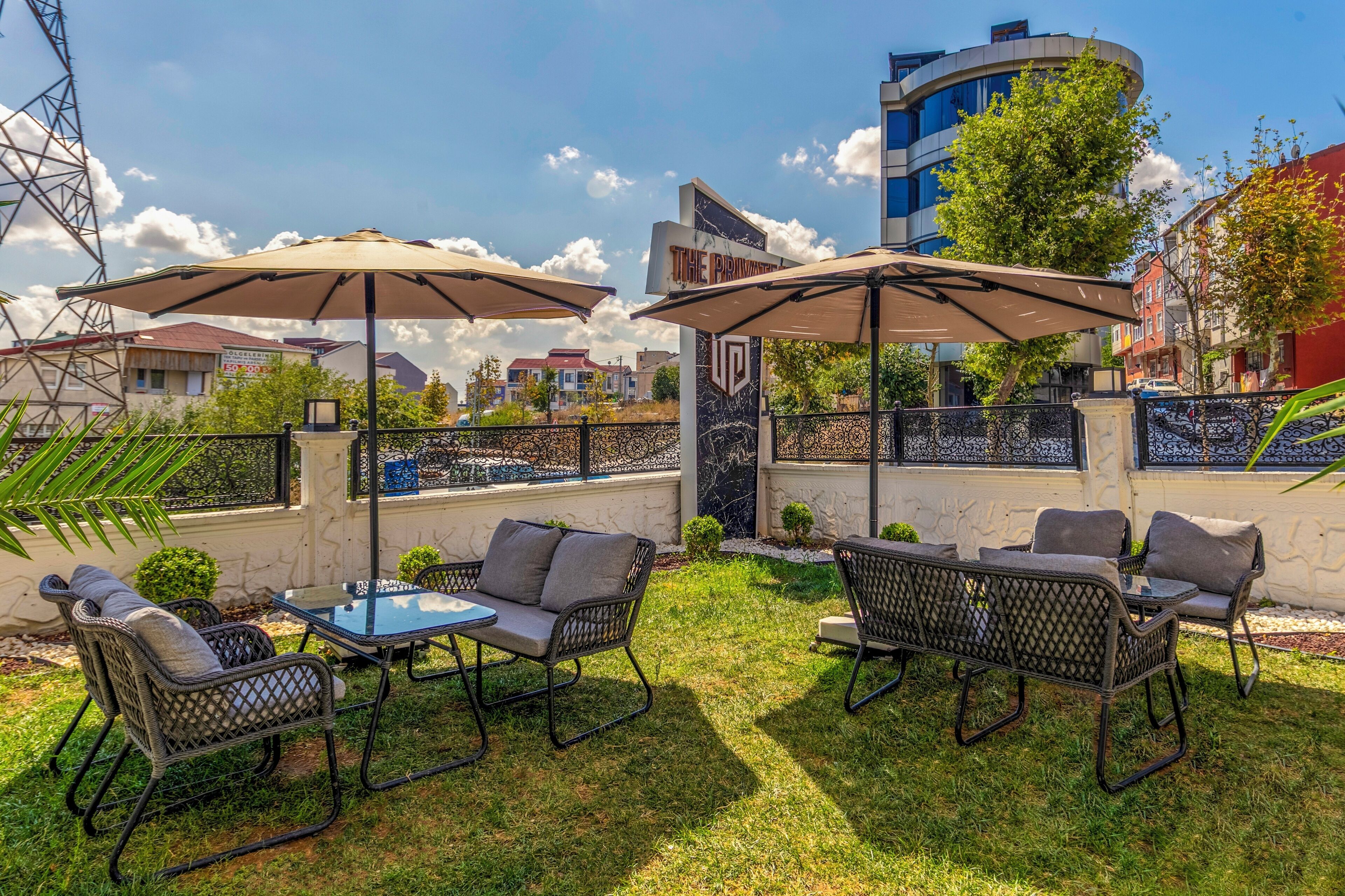 An outdoor seating area with tables and chairs, umbrellas, and a view of the cityscape.