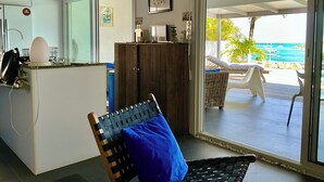 A modern kitchen with a white countertop, a wooden cabinet, and a chair with a blue cushion. - C'EST LA VIE !PRIVATE POOL AND AMAZING VIEWS ON PINEL ISLAND AND PETITE CLEF🌴 (Cul de sac)