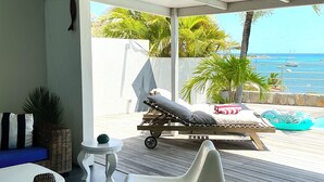 A sunlit room with a view of the sea, a lounge chair, a small table, and a wicker sofa. - C'EST LA VIE !PRIVATE POOL AND AMAZING VIEWS ON PINEL ISLAND AND PETITE CLEF🌴 (Cul de sac)