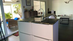 A modern kitchen with a central island, white cabinetry, and a built-in sink. - C'EST LA VIE !PRIVATE POOL AND AMAZING VIEWS ON PINEL ISLAND AND PETITE CLEF🌴 (Cul de sac)