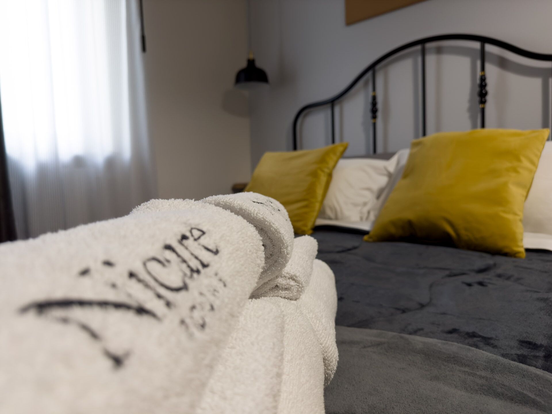 Ein Bett mit einer weißen Decke und zwei Kissen, eines gelb und eines weiß.