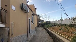 Une ruelle étroite, pavée de pierres, avec un bâtiment d’un côté.