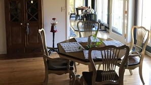 A dining area with a wooden table, chairs, and a ceiling fan. There is a cabinet with glass doors and a sign above it. - Nashville/Old Hickory Lake cottage (Mt. Juliet)