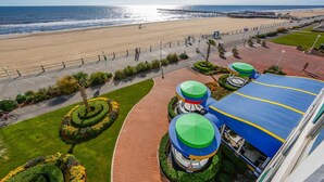 Une promenade en bord de mer, avec un sentier pavé, des jardins aménagés et une vue sur l’océan.