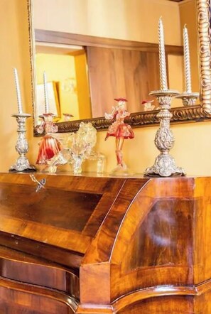 A wooden vanity with a mirror, candle holders, and decorative items.