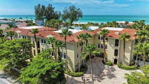 A coastal resort with multiple buildings, palm trees, and a view of the ocean. - La Casa Marie - 3 Bedroom Luxury Condo in Beachfront Complex - Anna Maria - By I (Holmes Beach)