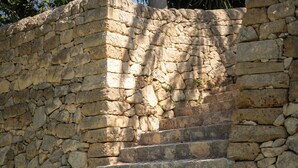 Una escalera de piedra que lleva a un muro de piedra.