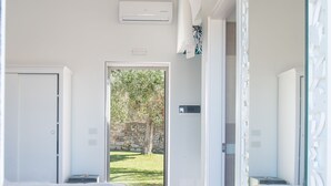 Un dormitorio moderno con una cama grande, un vestidor y vistas a un jardín.